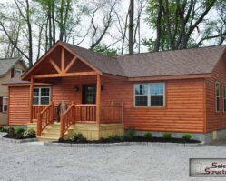 Premium modular log cabin by Salem Structures featuring a covered porch, rustic wood exterior, and residential-style windows—ideal for vacation homes or hunting cabins.