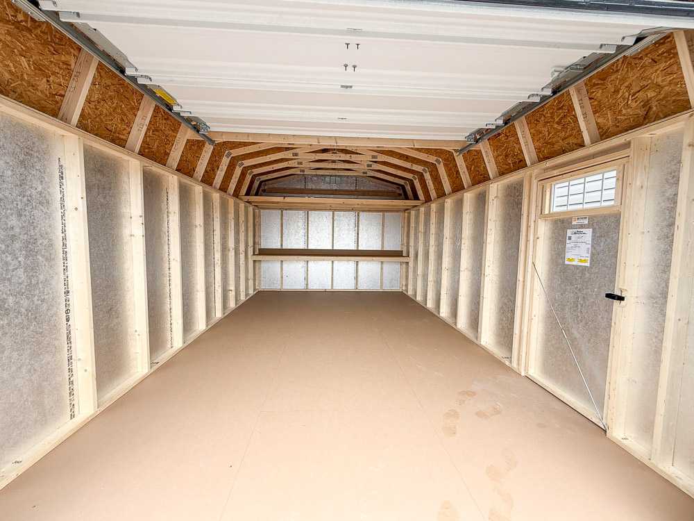 Interior view of a lofted barn-style storage shed with finished flooring and exposed trusses—ideal for spacious storage or workshop customization.