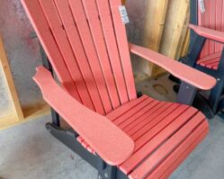 Coral red poly Adirondack chair displayed inside Salem Structures’ showroom, showcasing comfortable and maintenance-free outdoor furniture options.