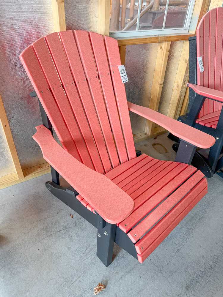 Coral red poly Adirondack chair displayed inside Salem Structures’ showroom, showcasing comfortable and maintenance-free outdoor furniture options.