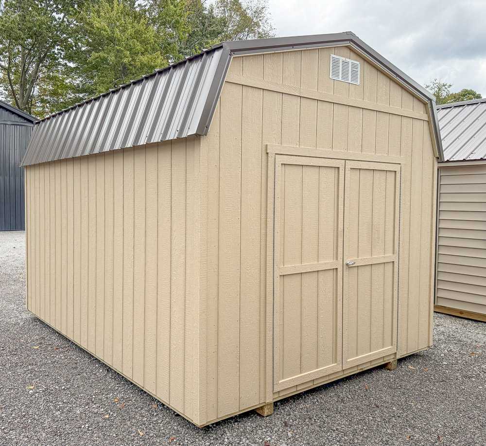 Tan gambrel barn-style storage shed from Salem Structures with metal roof, double front doors, and durable wood siding for backyard storage.